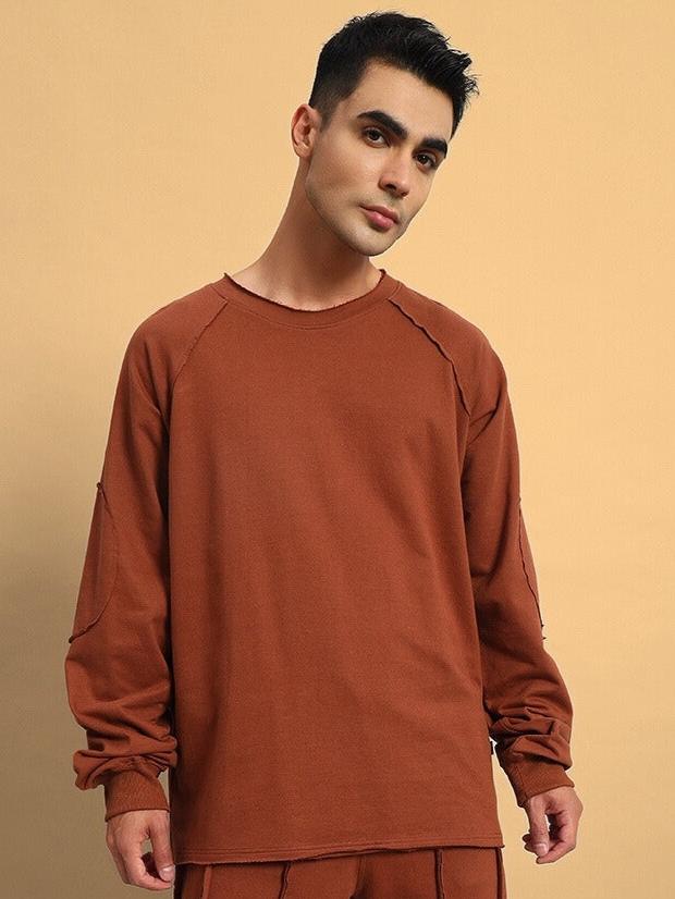 Model wearing LAMINA Oversized Sweatshirt in brown, crafted from premium cotton French terry with elastane. Ideal for casual wear.