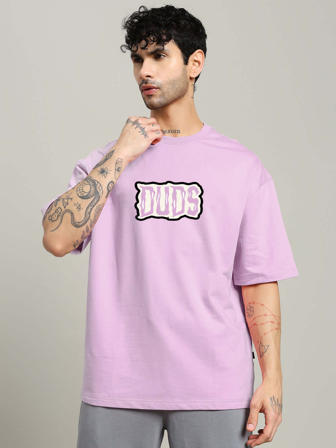Model wearing LET'S GET SPOOKY PRINTED OVERSIZED T-SHIRT LAVENDER with doodle graphics, showcasing streetwear style.