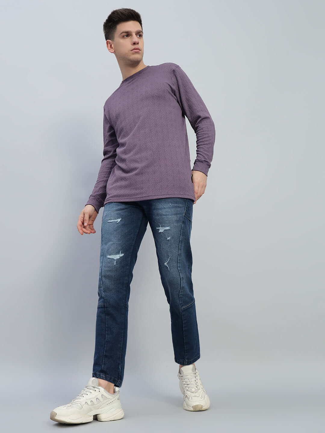 Model wearing Lavish Regular Fit Denim Jeans in Blue with casual purple top and white sneakers, showcasing stylish and comfortable look.