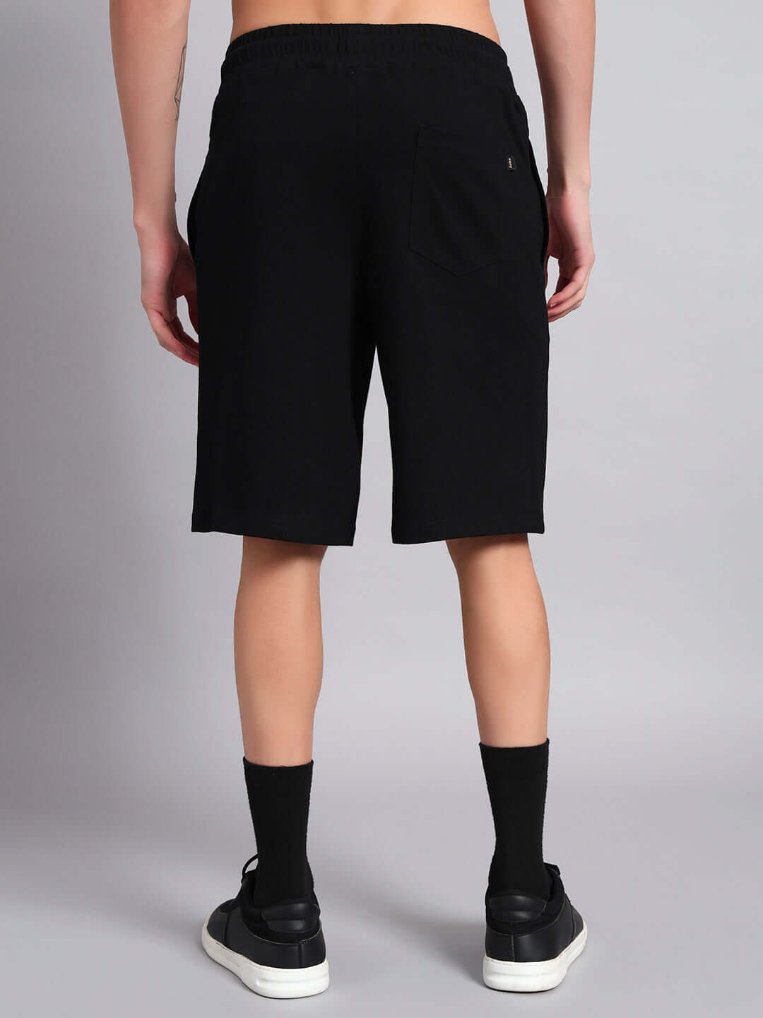 Back view of a person wearing black Lazio summer shorts, showcasing relaxed fit and casual style. Ideal for customizing fit.