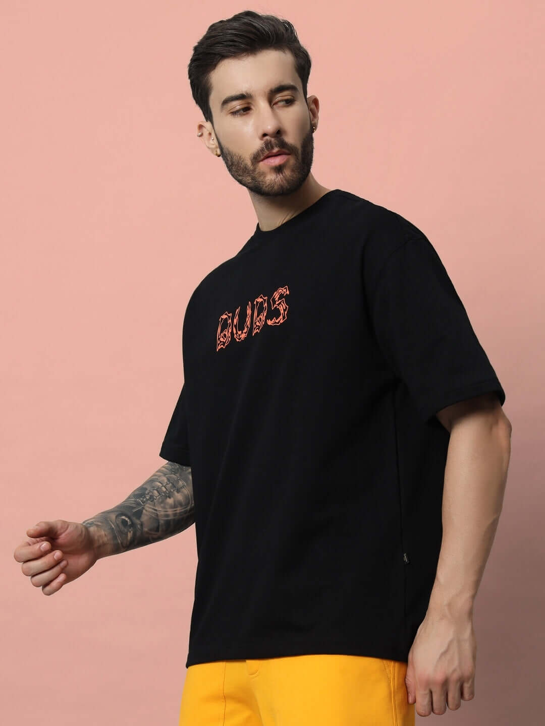 Man wearing LEO PUFF PRINT over-sized black T-shirt made from premium cotton with French terry fabric, featuring bold lettering.