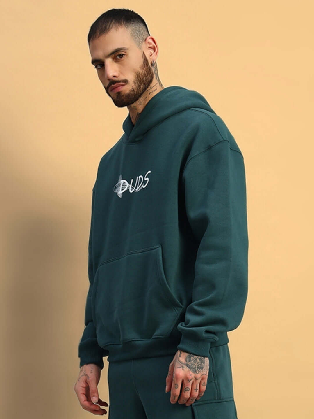 Model wearing LEOPARD SHARK FLEECE HOODIE TEAL GREEN by DUDS with front pocket and hood, made to order by experienced tailors, side view.