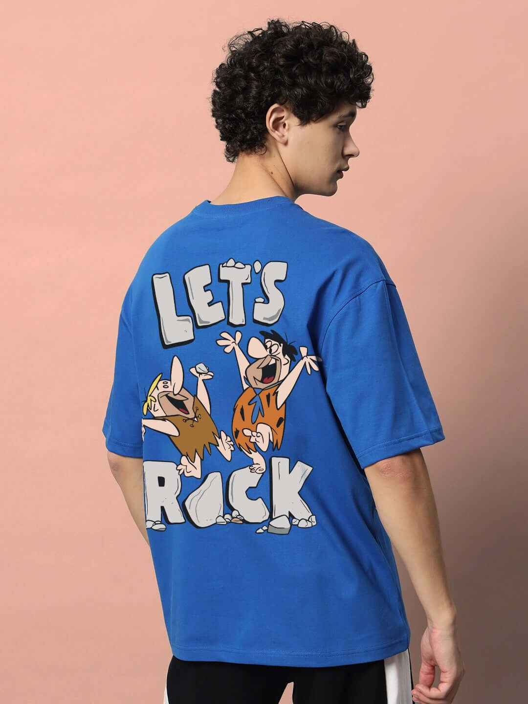 Royal blue oversized t-shirt featuring 'LET'S ROCK' design with colorful cartoon characters on the back. Made from premium cotton blend.