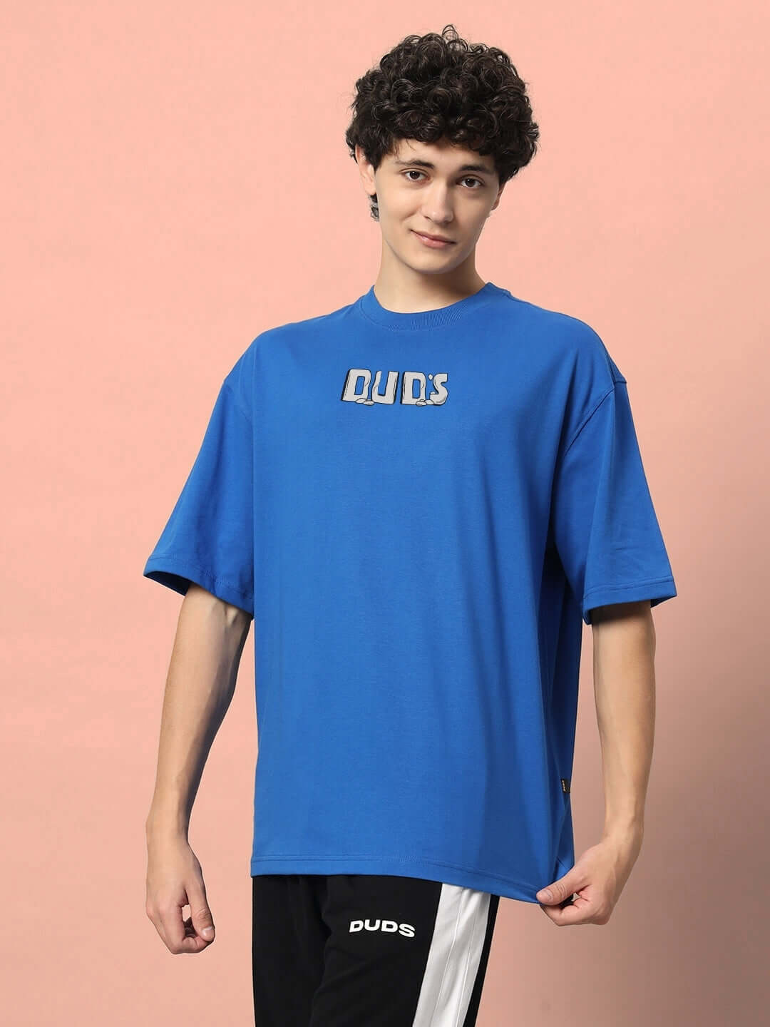Person wearing a royal blue oversized t-shirt with 'DU.DS' text, made from premium cotton French terry, ideal for casual wear.