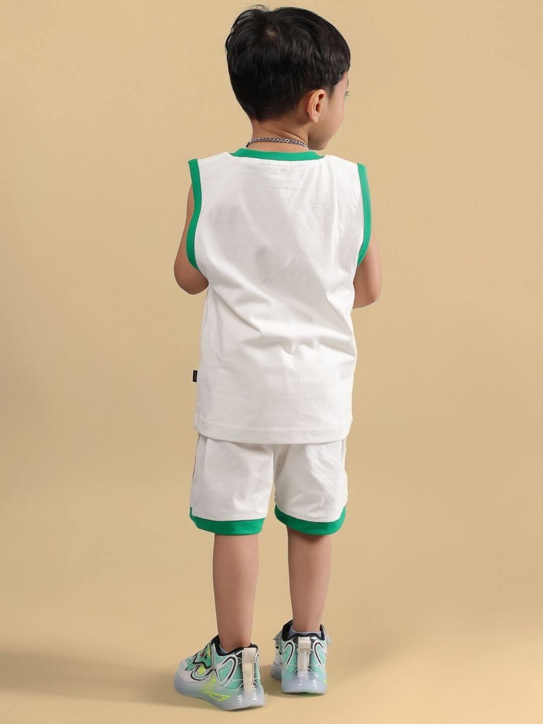 Back view of child wearing Let's Smile Co-Ord in off white, featuring green trim and matching shorts, showcasing playful, comfortable style.