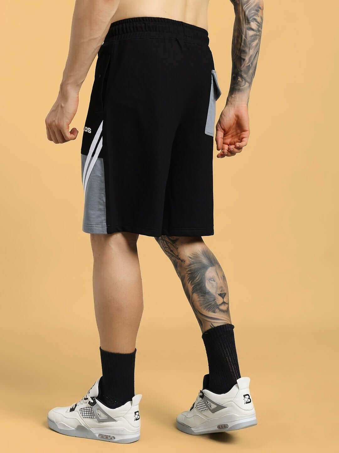 Back view of LEWIN CHINO REGULAR FIT SHORTS BLACK-GREY worn by model with black socks and white sneakers.