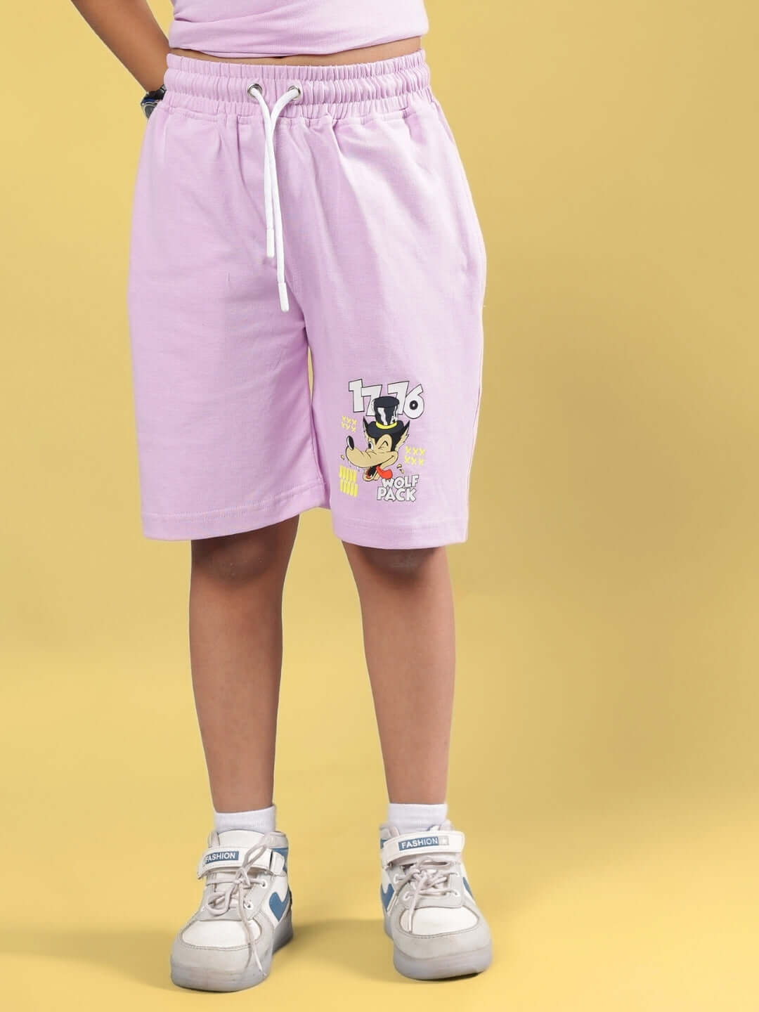 Child wearing WOLF PACK SHORTS FOR BOYS & GIRLS LILAC with cartoon print.