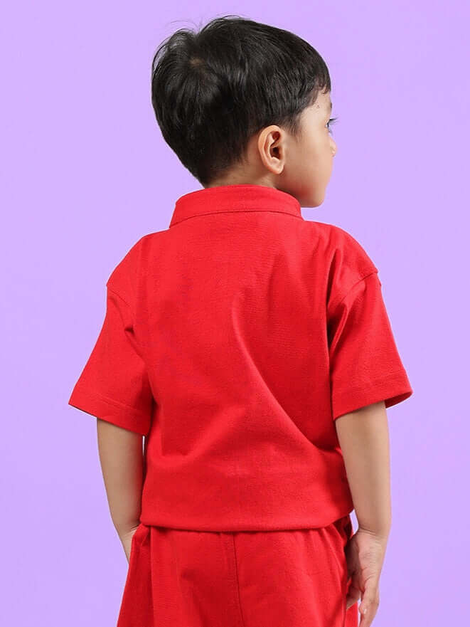 Back view of a child wearing the red Limbo shirt designed for boys and girls, showcasing the vibrant color and tailored fit on a purple background.