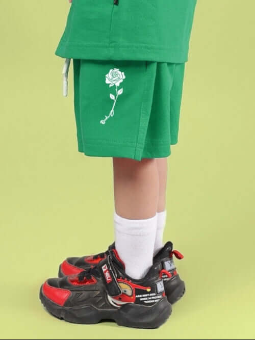 Child wearing LIMBO SHORTS FOR BOYS & GIRLS GREEN with a floral design, showcasing casual style and comfort for kids.