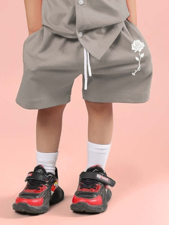Child wearing LIMBO SHORTS FOR BOYS & GIRLS GREY paired with sporty shoes, showcasing comfortable and stylish kids' fashion.