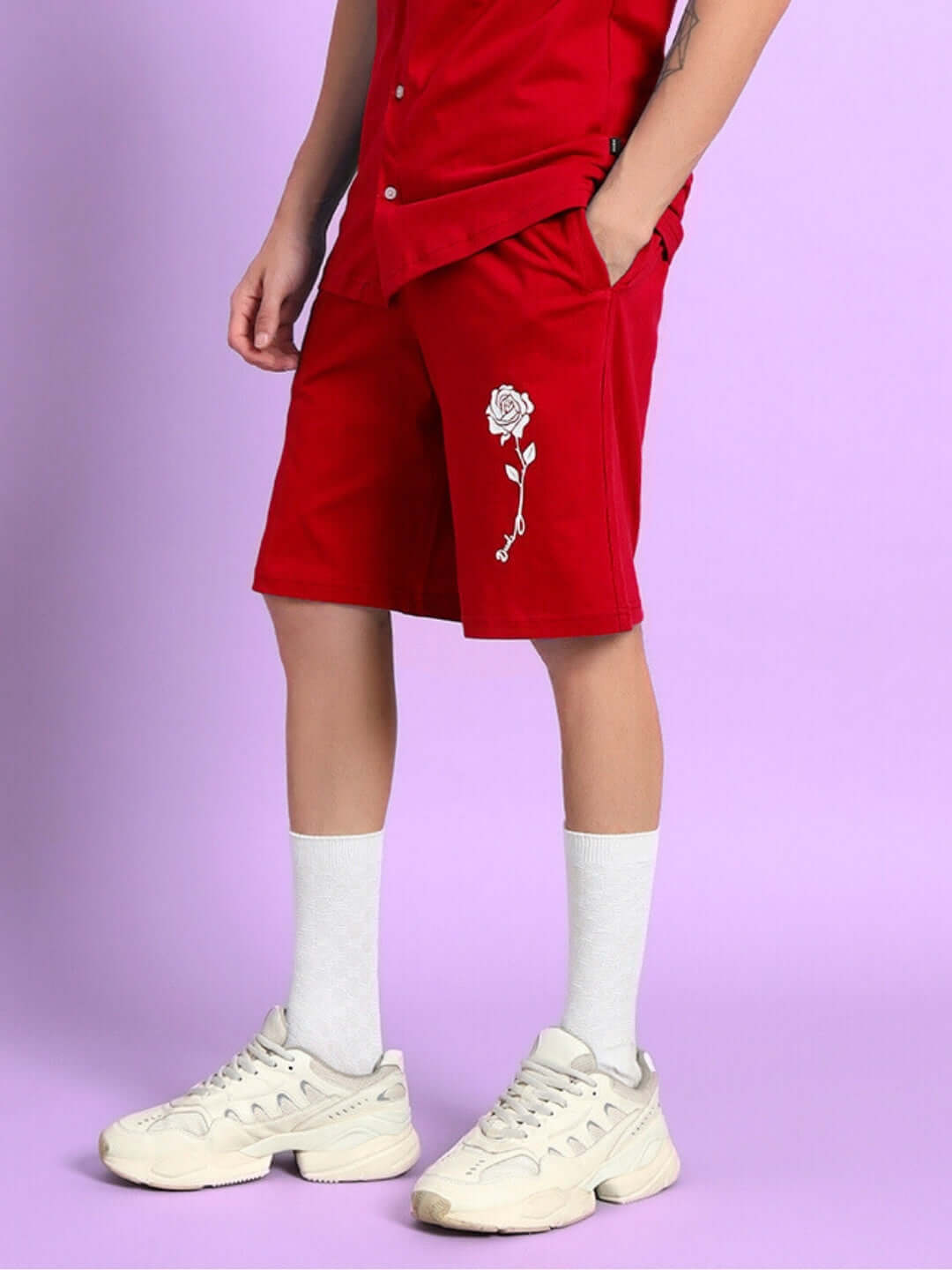 Person wearing LIMBO SUMMER COTTON SHORTS RED with white sneakers, showcasing vibrant style and comfort.