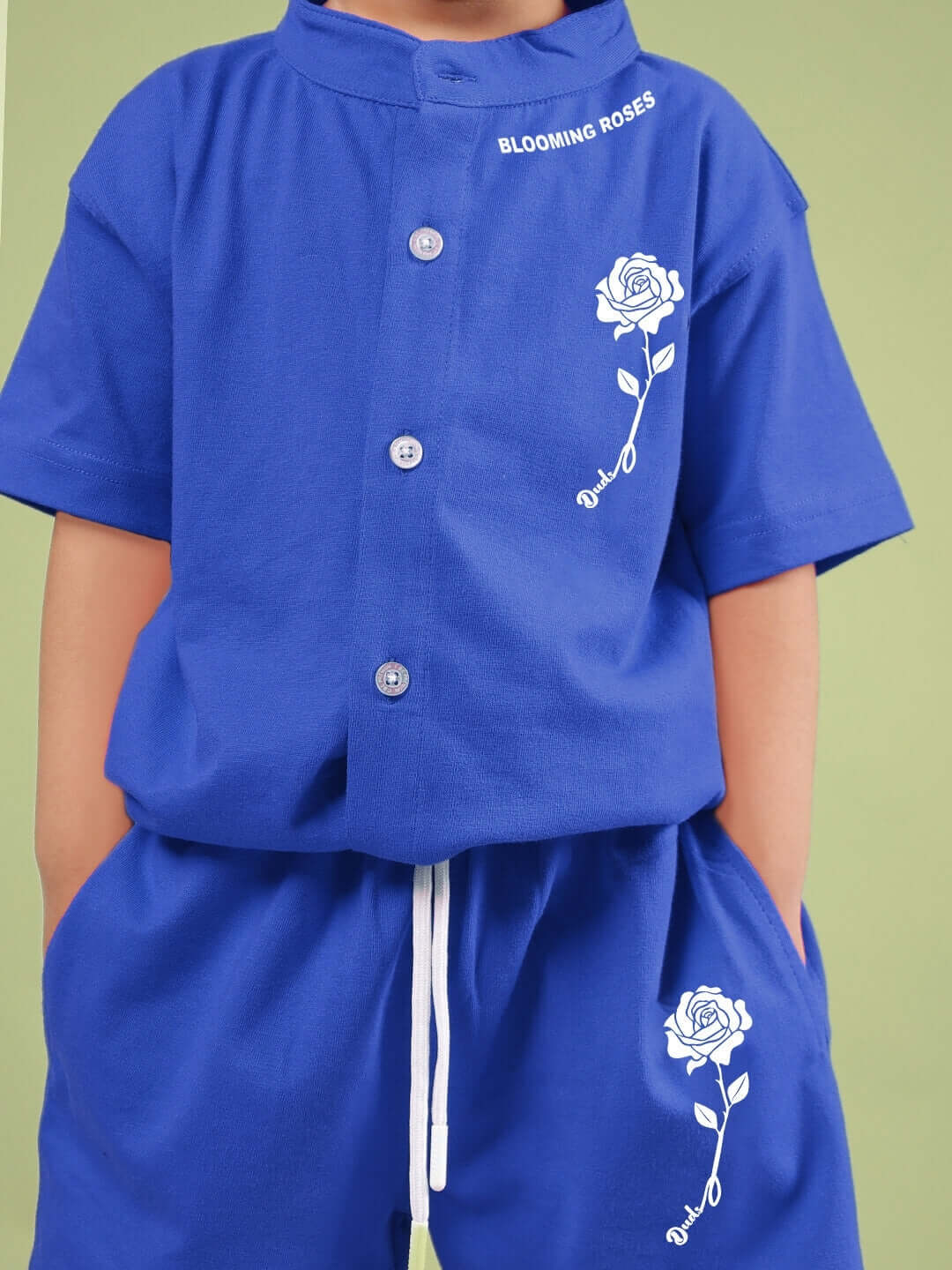 Child wearing LIMBO CO-ORD FOR BOYS & GIRLS BLUE with floral design on shirt and shorts.