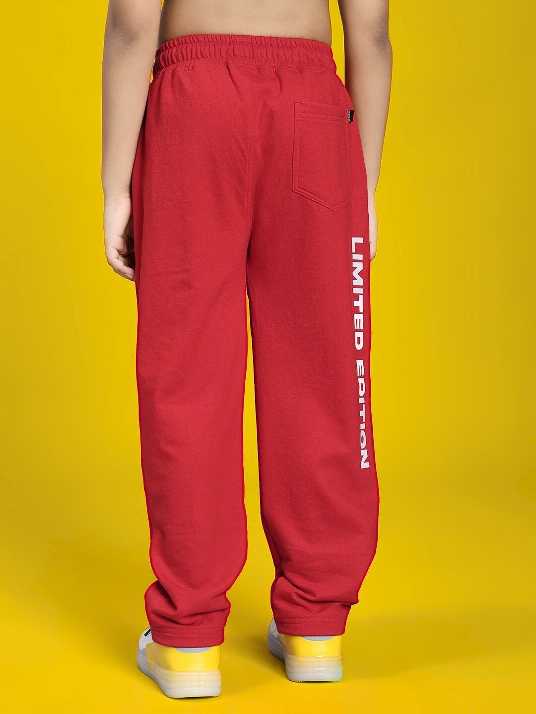 Back view of LIMITED EDITION JOGGER FOR BOYS AND GIRLS RED in vibrant color on yellow background.