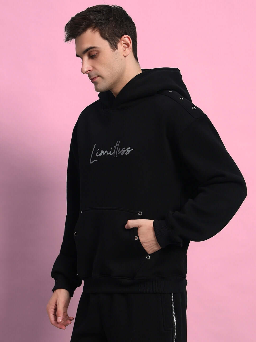 Black Limitless Reflector Hoodie with fleece, featuring a stylish design, worn by a person against a pink background.