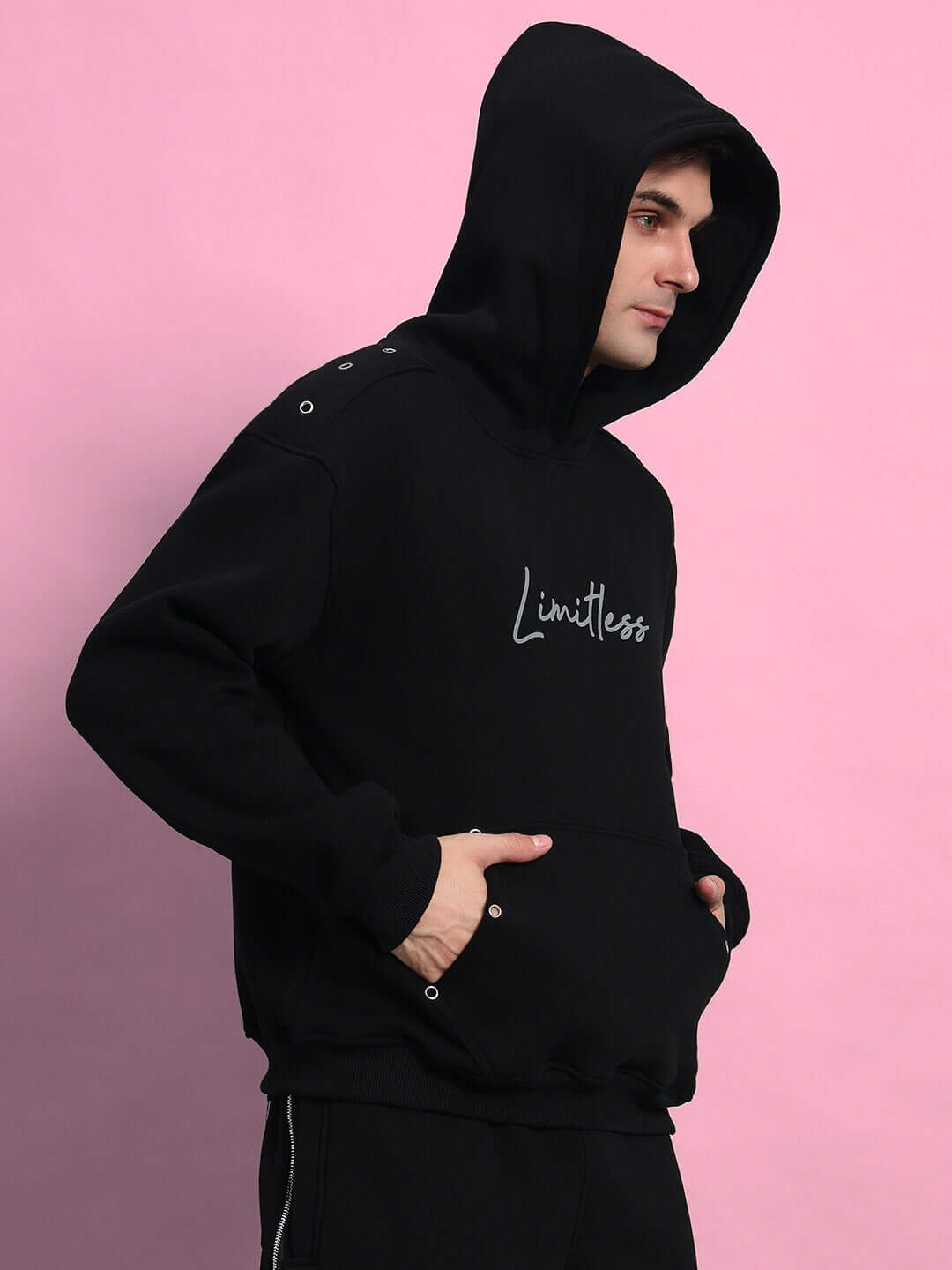 Man wearing Limitless Fleece Reflector Hoodie in Black, stylish and comfortable with kangaroo pocket and reflective detailing.