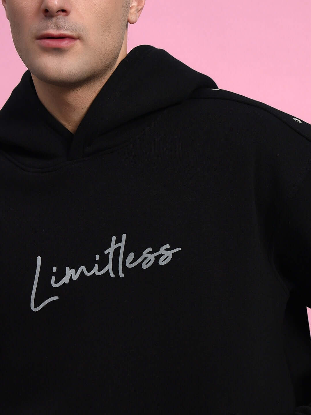 Black Limitless Fleece Reflector Hoodie with hood, worn by model. Stylish and comfortable design for active lifestyle or casual wear.