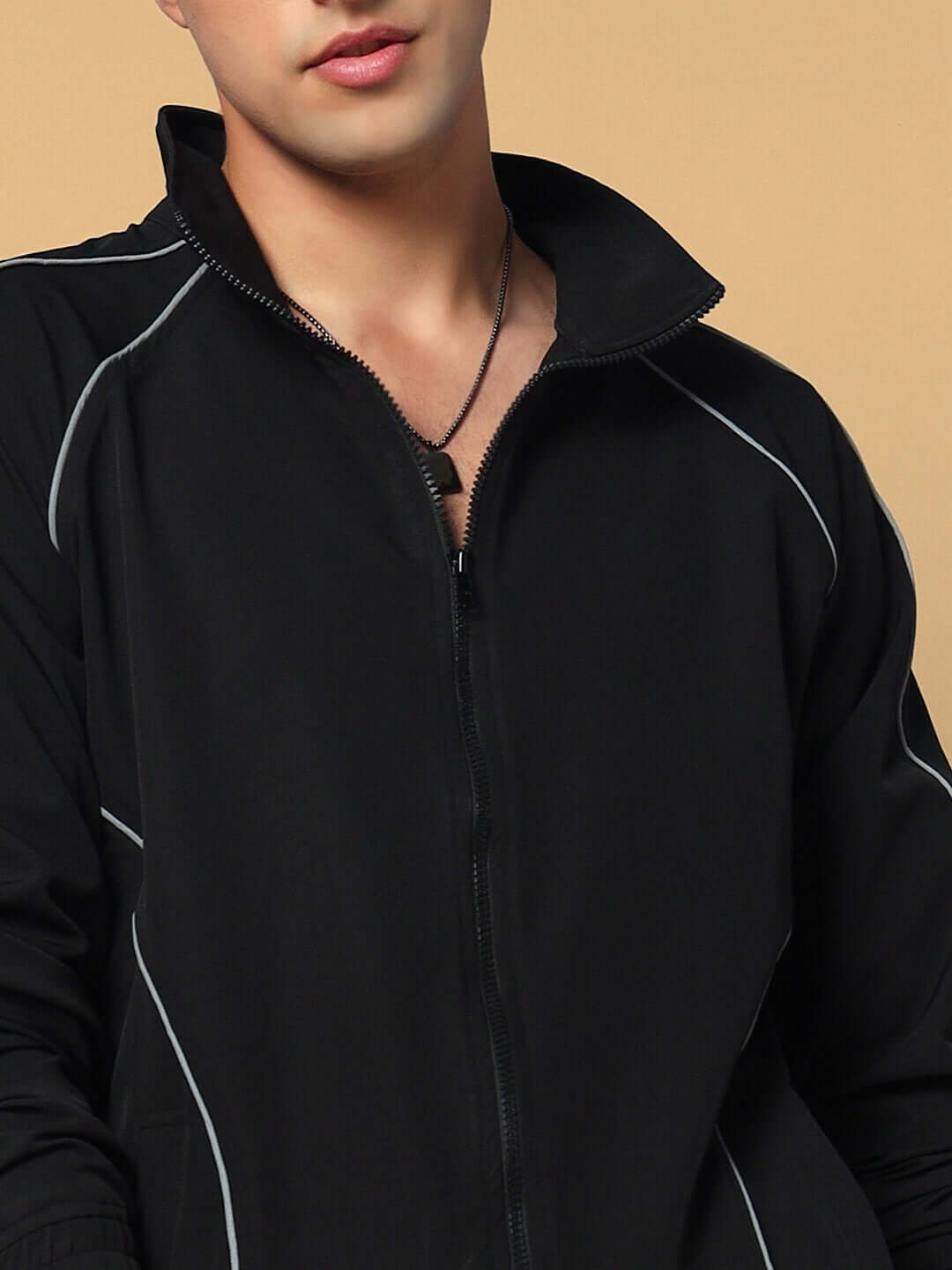 Man wearing a LOCO REFLECTOR Parachute Sports Jacket in black with zipper front and reflective piping, made by DUDS tailors.