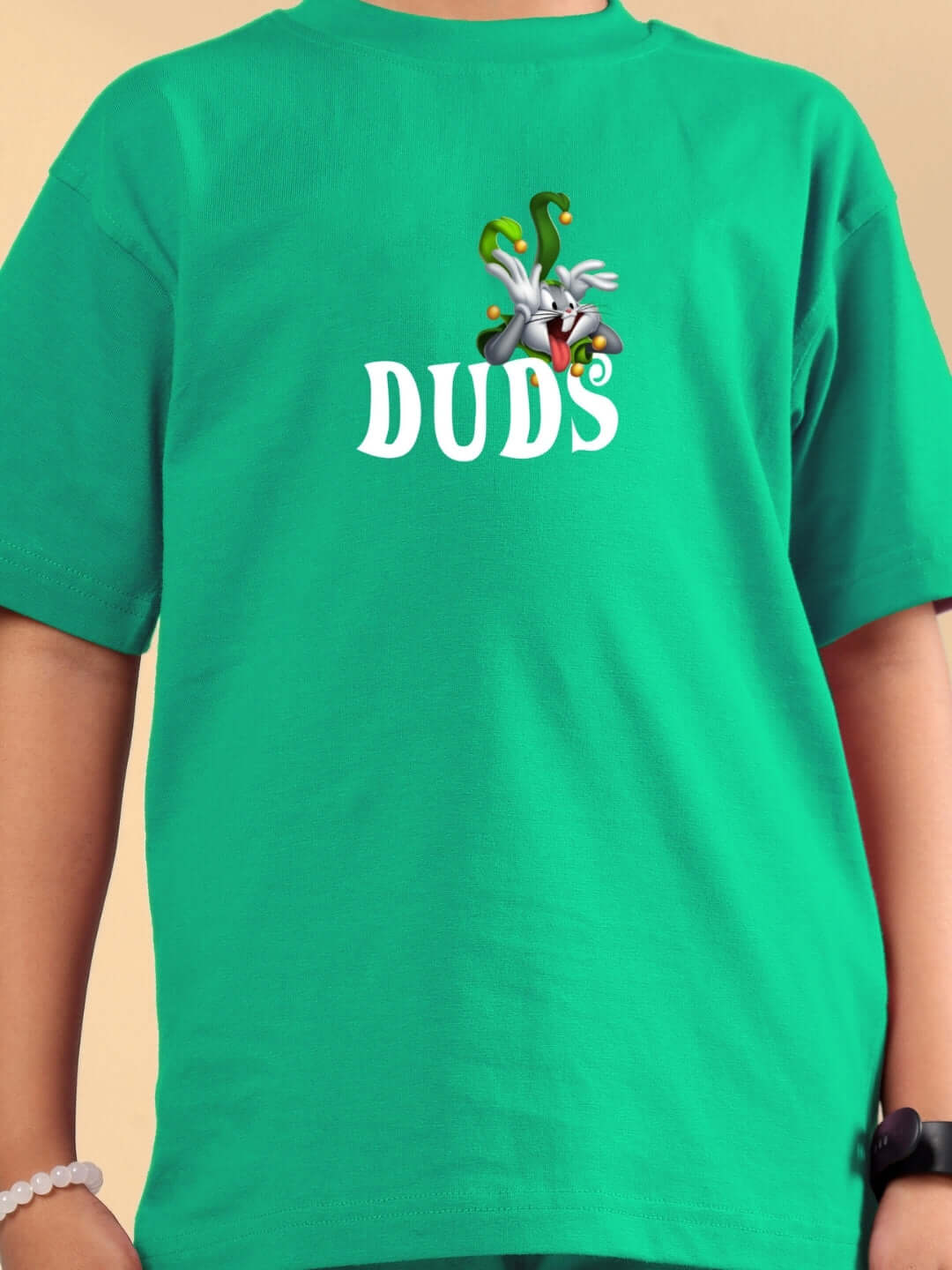 Child wearing LOONEY TUNES PRINTED CO-ORD FOR BOYS & GIRLS GREEN with DUDS logo and cartoon graphic, made to order.