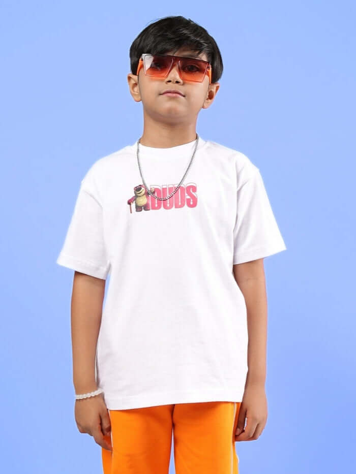 Child wearing a white oversized LOTSO T-shirt by DUDS, styled with sunglasses and orange pants, perfect for boys and girls.
