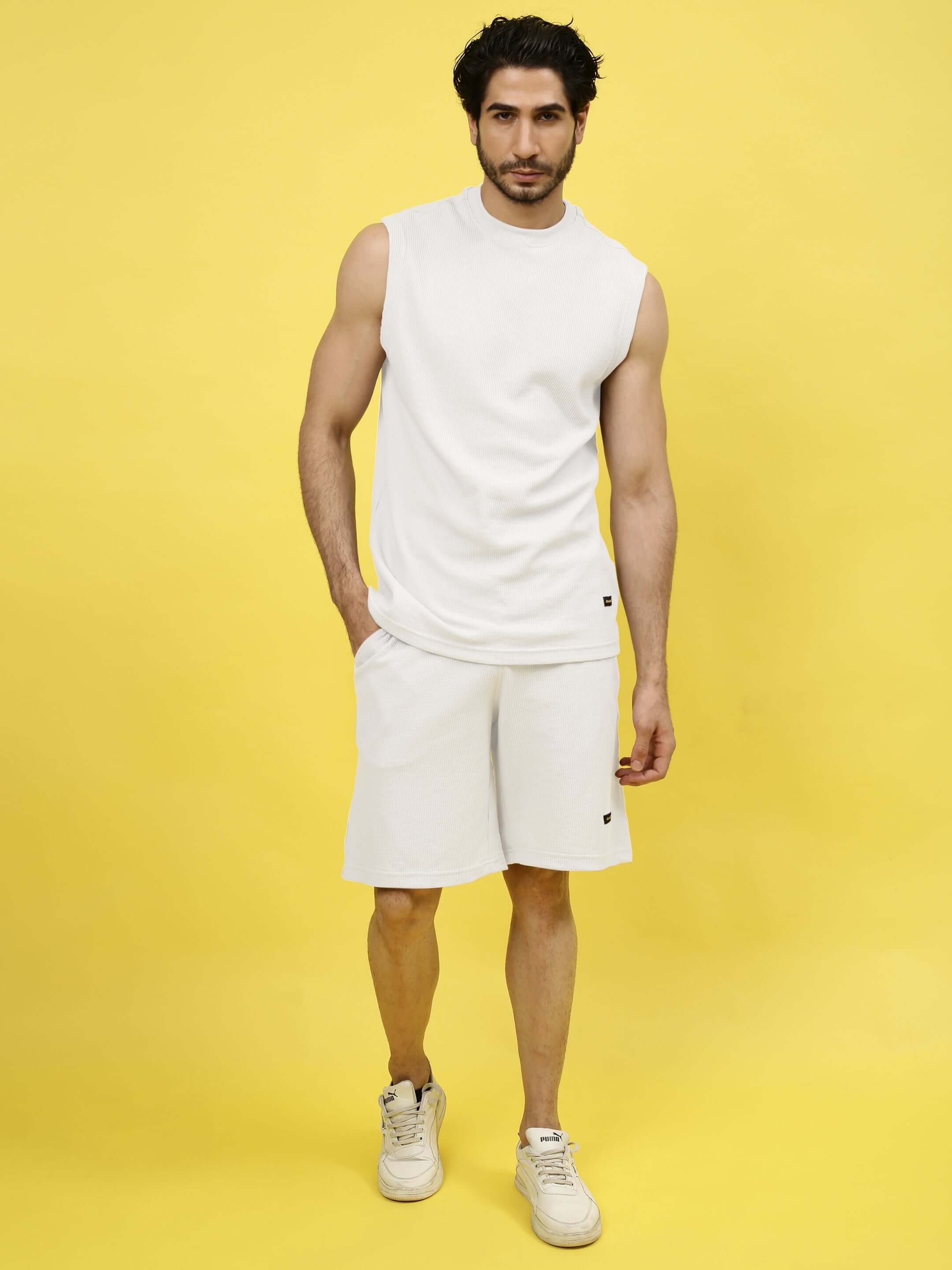 Man wearing off-white co-ord set made from premium waffle cotton fabric, modeling against a bright yellow background.