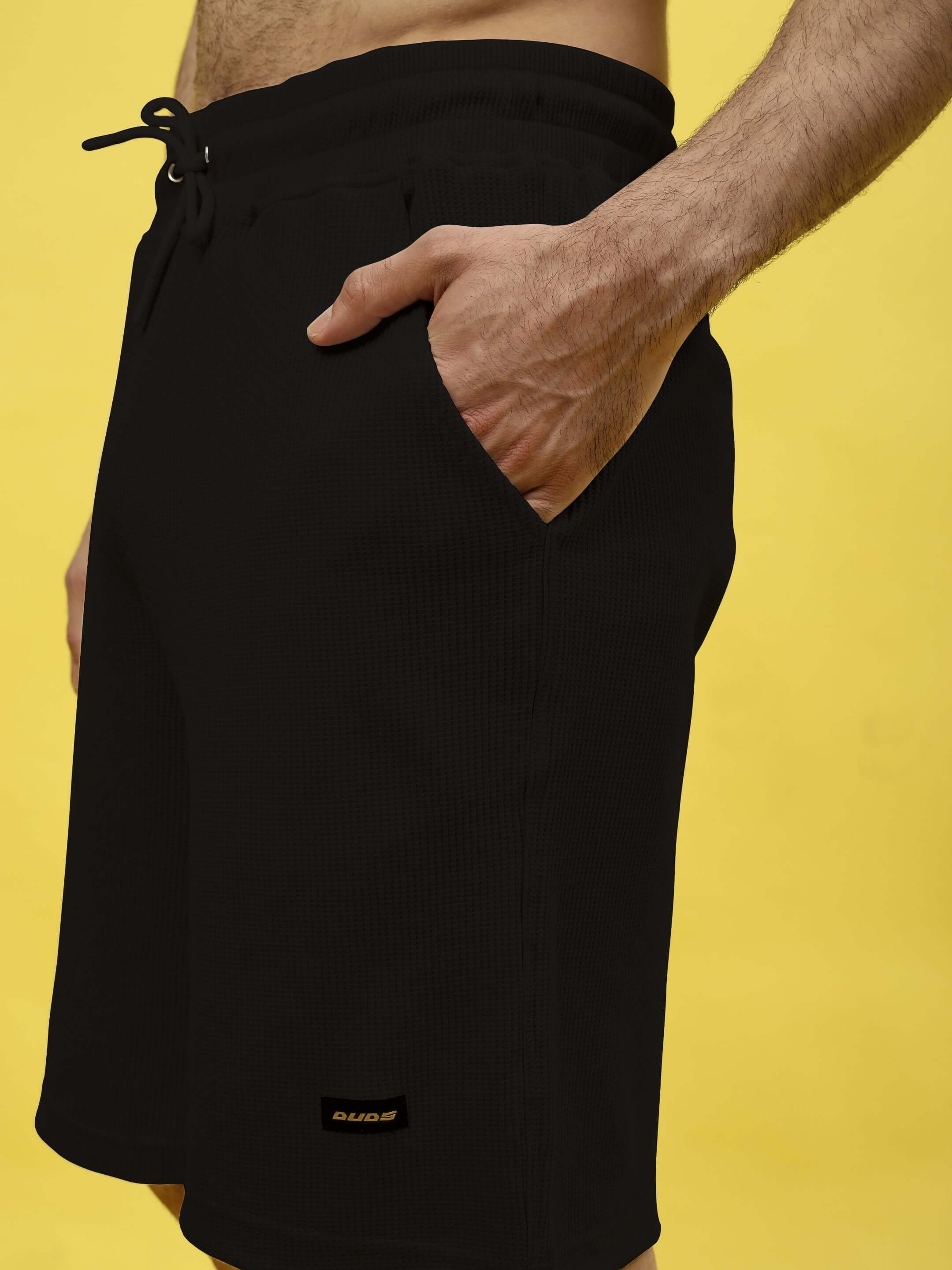 Low-key solid black co-ord shorts in premium heavy gauge waffle fabric, 100% cotton, 240 GSM, featuring a drawstring and pocket.