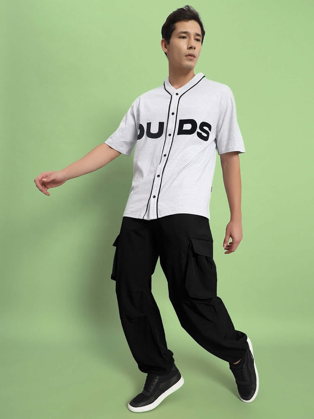Model wearing Mabel Relaxed Fit Cargo Pants in black with a gray DUDS shirt against a green background