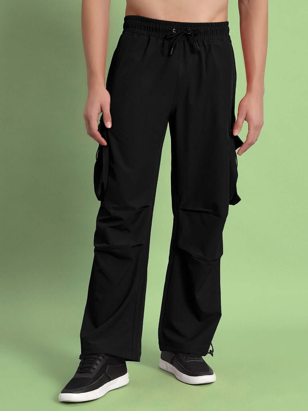 Model wearing black MABEL relaxed fit cargo pants with elastic waist and side pockets, styled with casual sneakers.