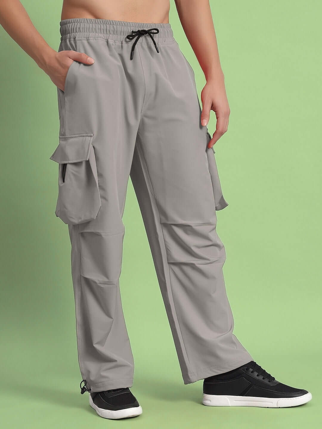 Mabel relaxed fit grey cargo pants with customizable size option and elastic waistband, displayed on model against green background.