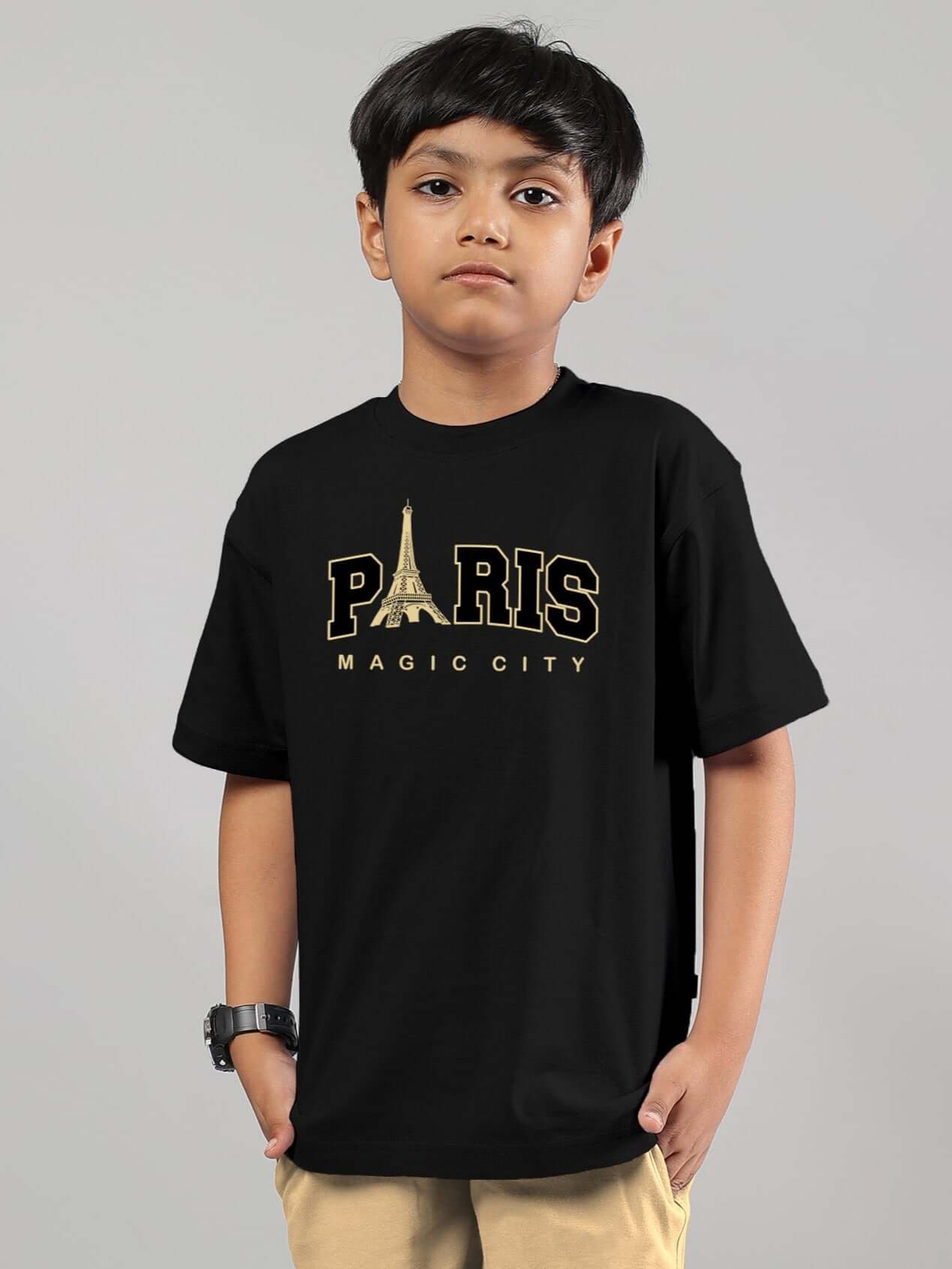Child wearing a black MAGIC CITY T-shirt for boys and girls, featuring 'Paris' text with Eiffel Tower graphic, made to order by DUDS.