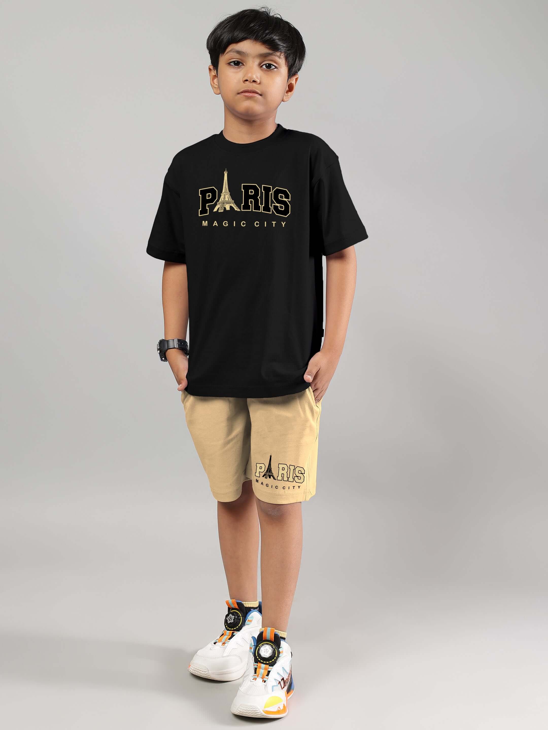 Child wearing MAGIC CITY SHORTS FOR BOYS GIRLS BEIGE paired with a black t-shirt and sneakers.