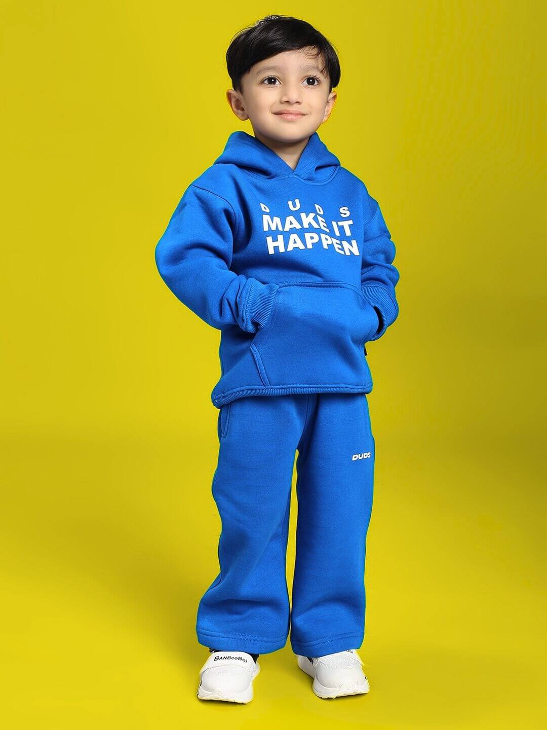 Child wearing MAKE IT HAPPEN FLEECE CO-ORD FOR BOYS AND GIRLS ROYAL BLUE, standing confidently in a cozy hooded sweatshirt and pants set.