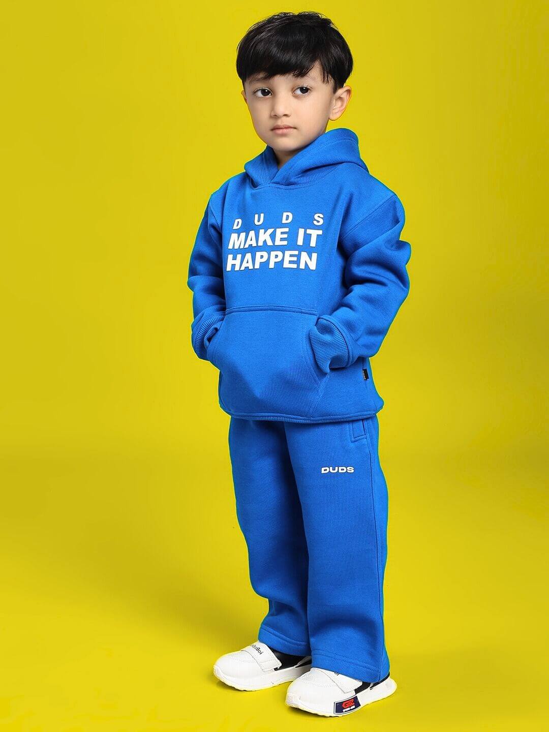 Child wearing MAKE IT HAPPEN FLEECE CO-ORD FOR BOYS AND GIRLS ROYAL BLUE, standing confidently on a yellow background.