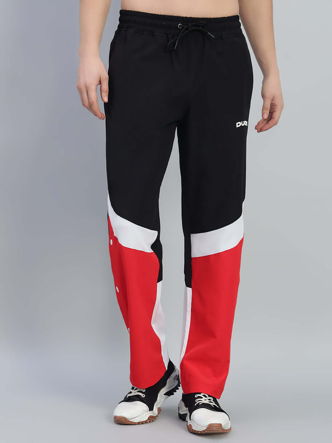 Model wearing MARCO RELAXED FIT CARGO PANTS BLACK RED with bold red accents and utility pockets, showcasing streetwear style.