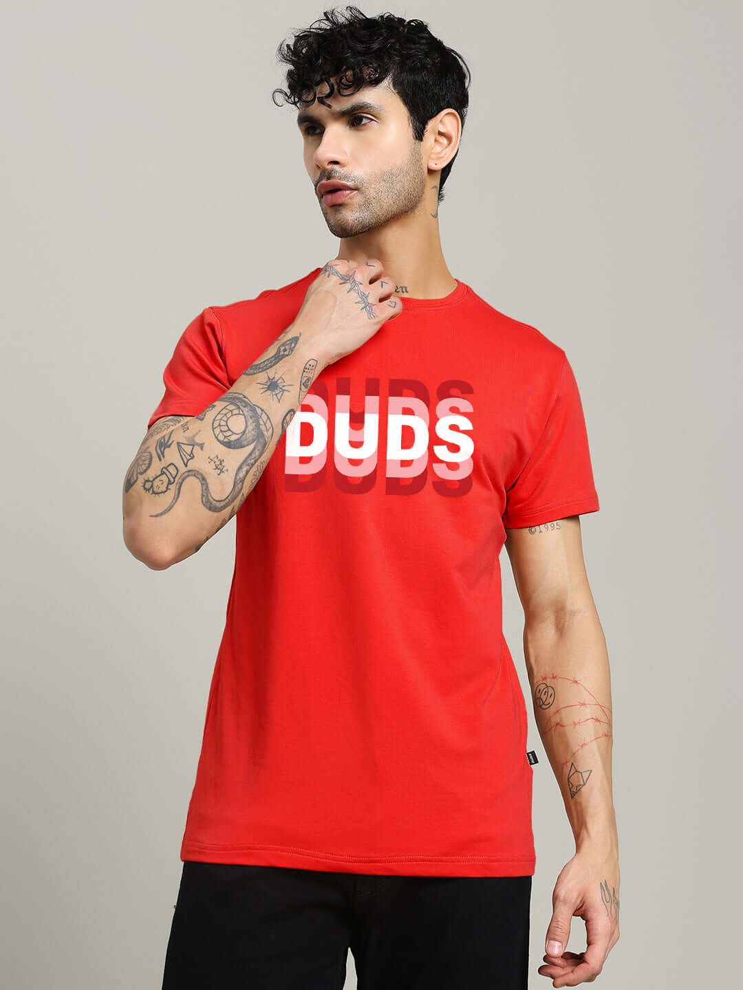 Man wearing MARK REGULAR FIT COTTON T-SHIRT RED with graphic lettering, standing against a neutral background.