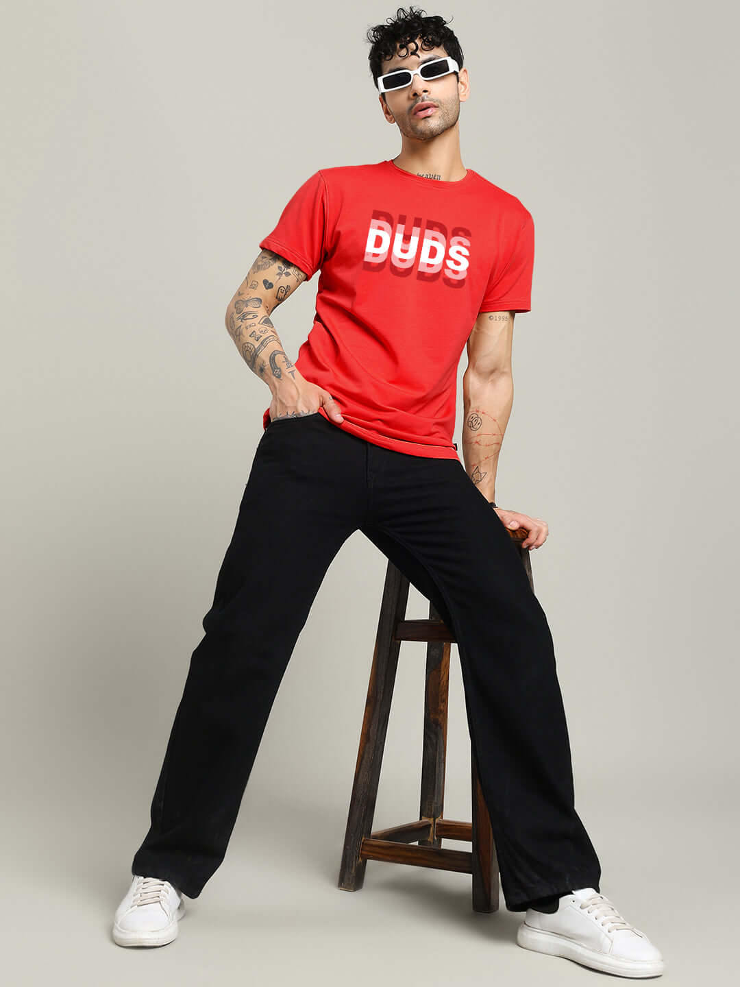 Model wearing MARK REGULAR FIT COTTON T-SHIRT RED with sunglasses, showcasing a casual style with black pants.