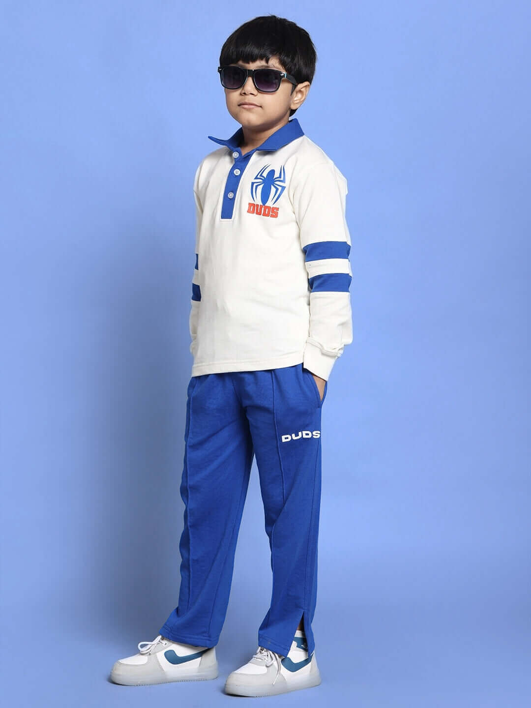 Child wearing Marvel oversized sweatshirt in white and royal blue with Spider-Man print, paired with matching blue pants, stylish in sunglasses.