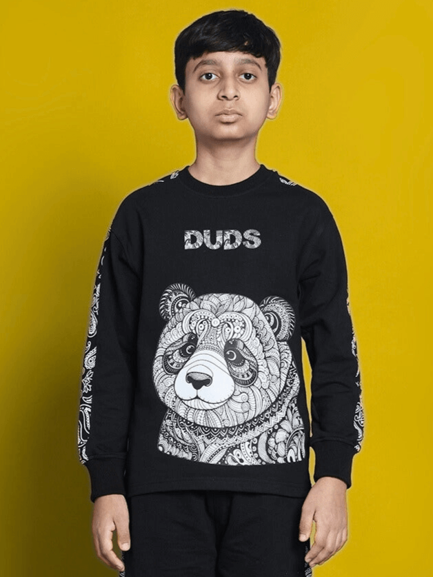 Boy wearing black Masha oversized sweatshirt with panda design, suitable for boys and girls, made of 100% cotton, in vibrant setting.