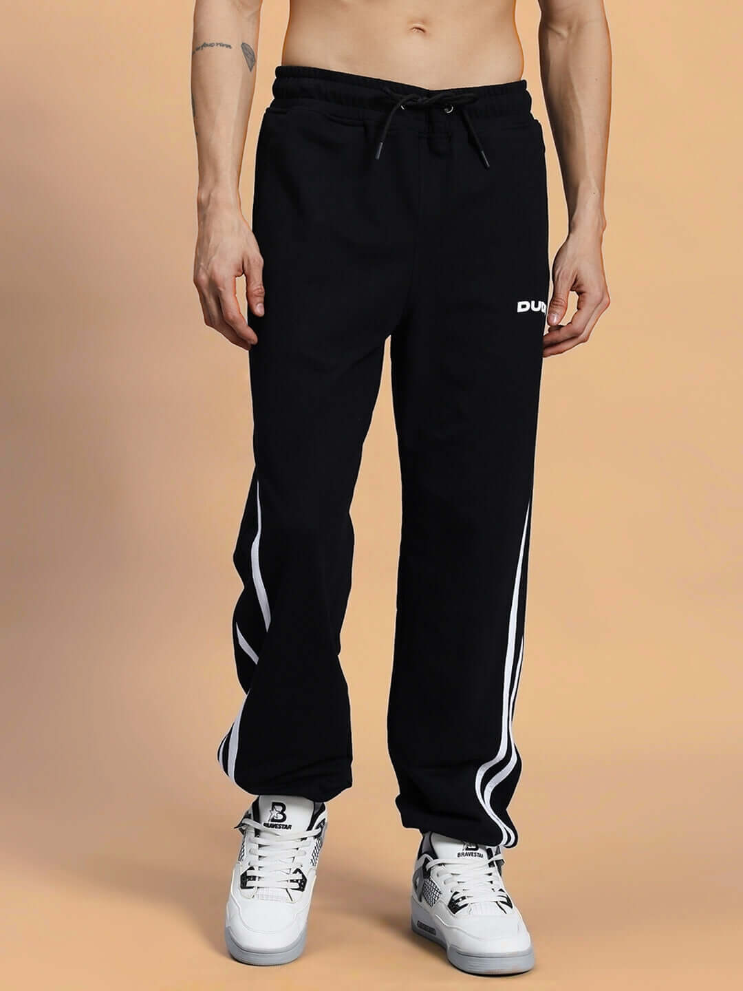 Model wearing MEGASTAR 2 Stripe Jogger in black with white stripes, showcasing comfortable and customizable fit.