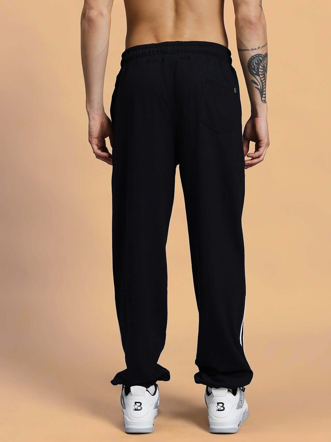 Back view of black MEGASTAR 2 Stripe Jogger worn by a model, showcasing its custom-fit design and comfortable tailored craftsmanship.