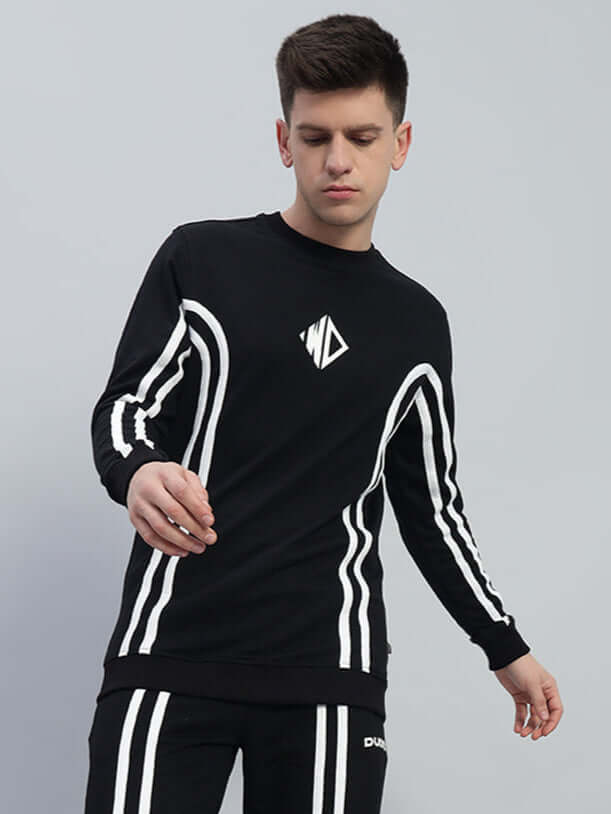 Model wearing OUTLOOK black sweatshirt with white striped design, made of premium cotton French terry. Stylish and comfortable fashion wear.
