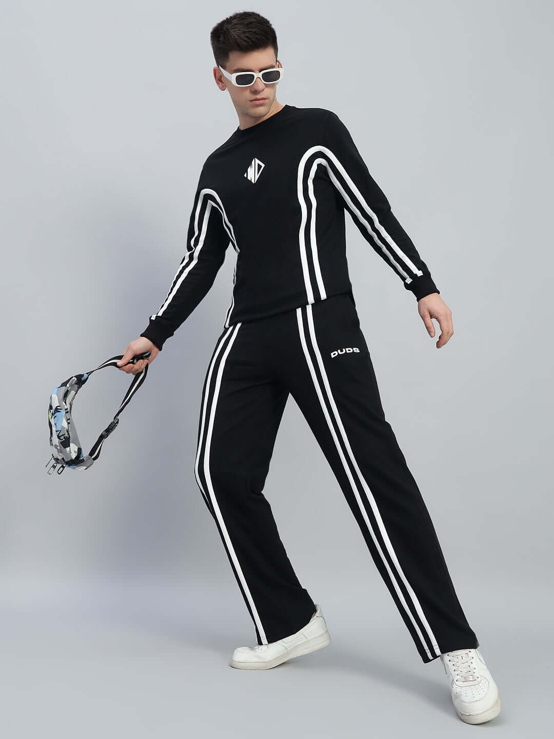 Model wearing black Outlook co-ord set with white stripes, featuring relaxed fit joggers and customizable drawstring waistband.