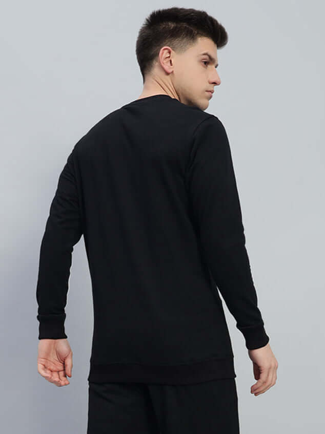 Side view of a man wearing a black premium Outlook sweatshirt made from cotton French terry lycra, showcasing its tailored fit and style.