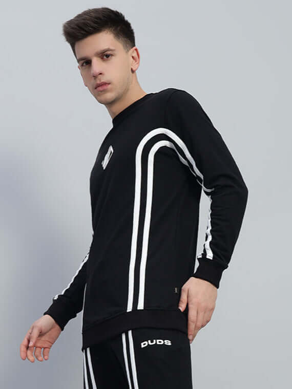 Model wearing OUTLOOK black sweatshirt with white stripes, made from premium cotton French terry, ideal for stylish comfort.