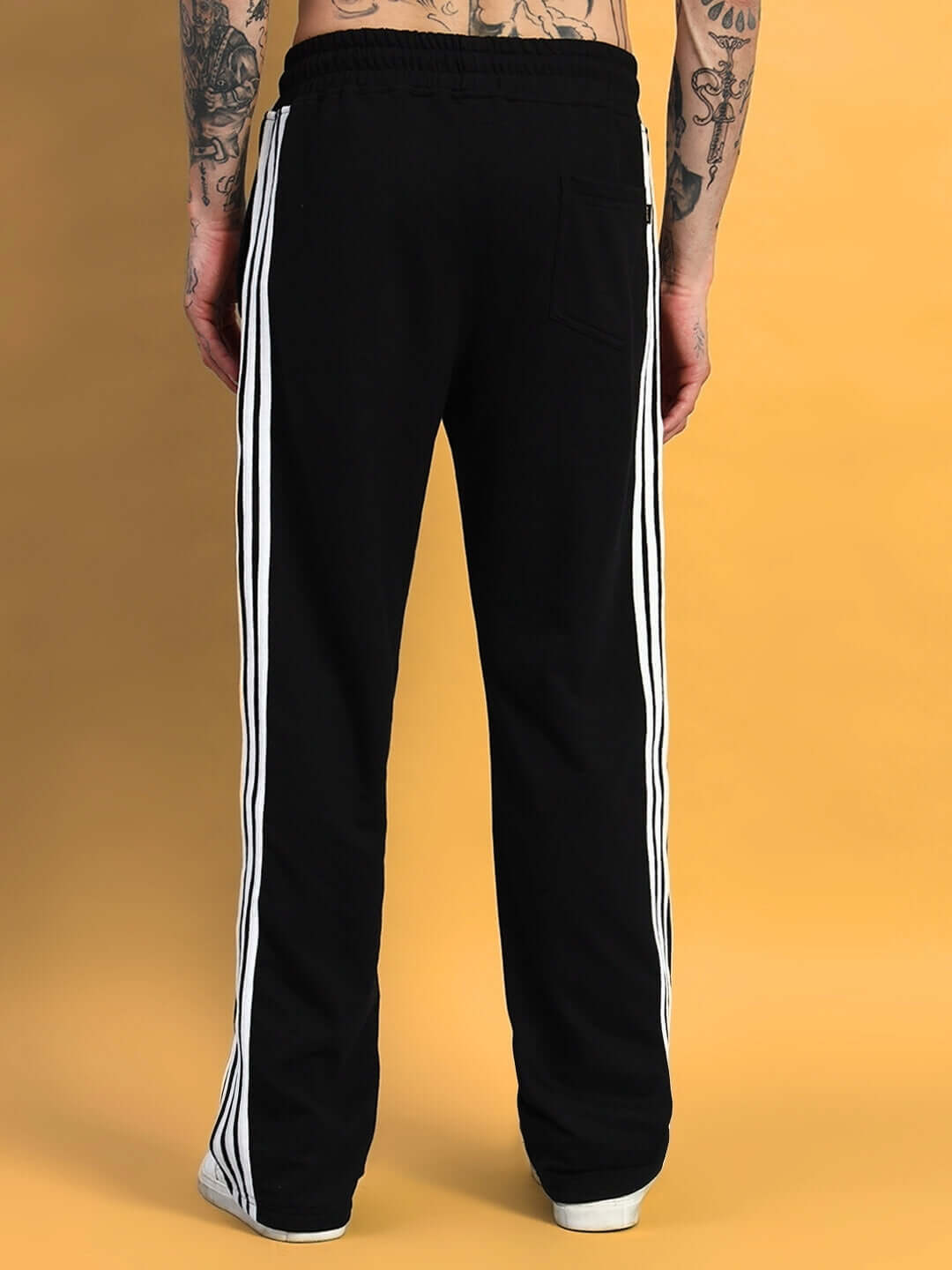Back view of black jogger pants with white side stripes, made to order by DUDS, customizable fit available.