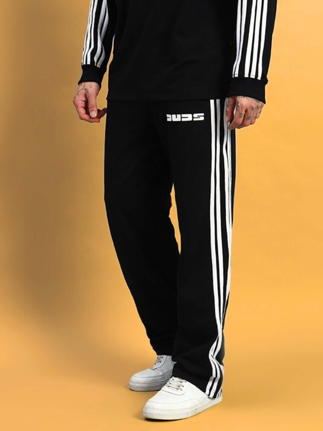 Black parka jogger pants from DUDS with white vertical stripes, worn with white sneakers.