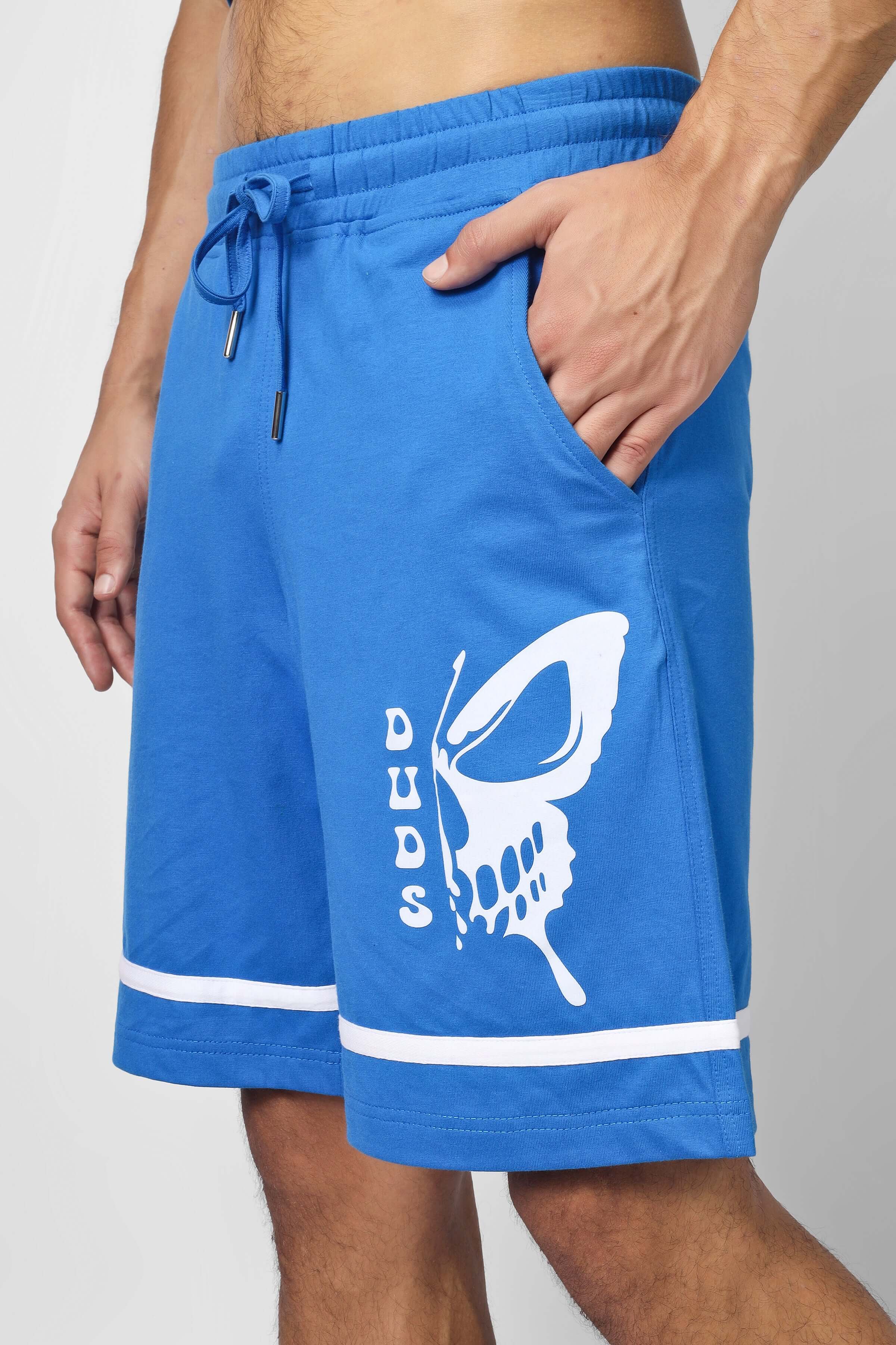 Man wearing blue shorts with skull butterfly print from CO-ORD SET WITH SKULL BUTTERFLY PRINT BLUE