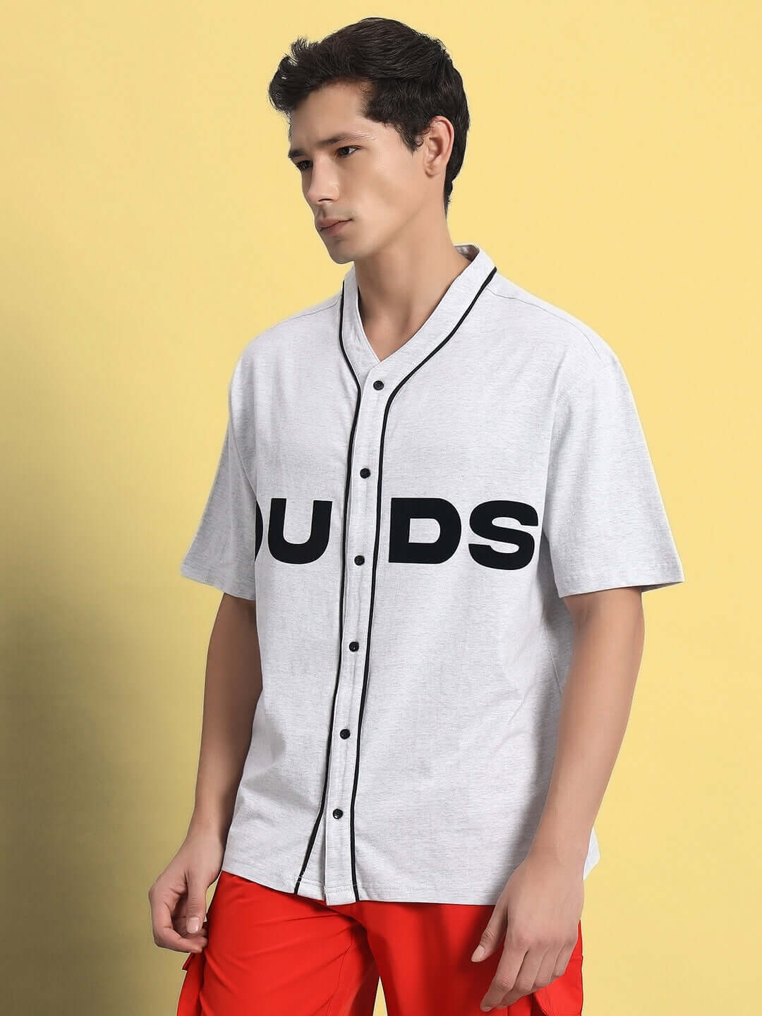 Male model wearing ZING Raglan Oversize T-Shirt in Melange Grey with Mandarin collar, showcasing casual style with vibrant red pants.