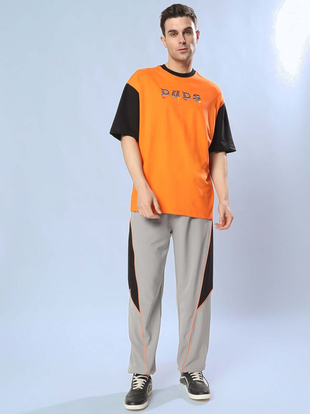 Person wearing Furious Relaxed Fit Cargo Pants in grey paired with an orange and black DUDS t-shirt.