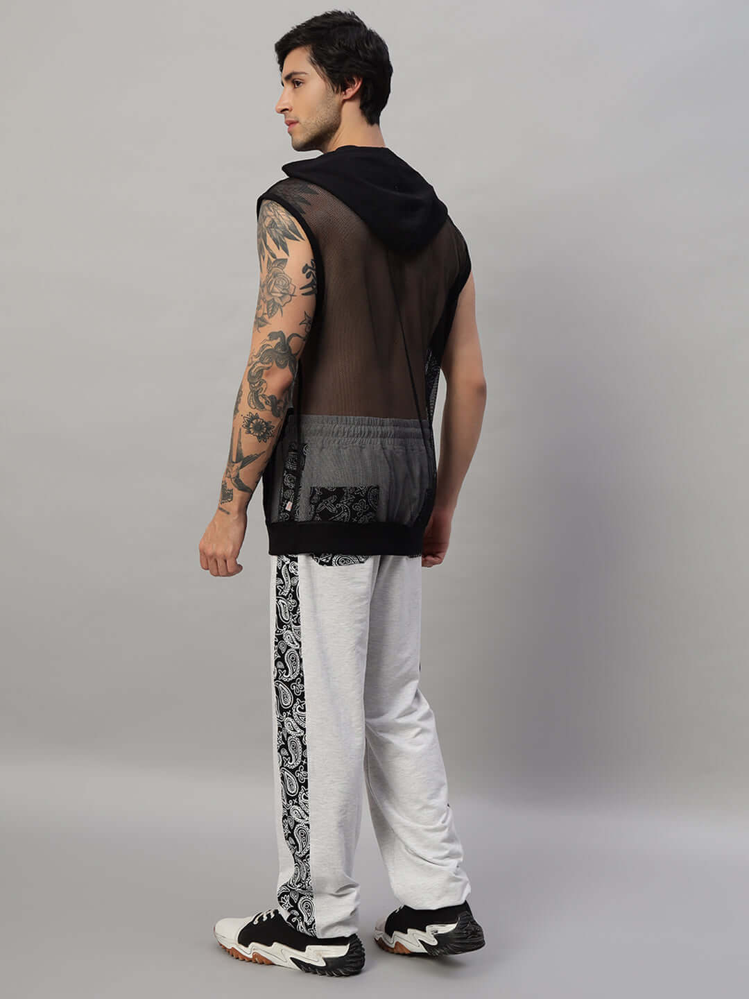 Back view of a person in a BOOGIE OVERSIZED CO-ORD SET MELANGE GREY with a black sleeveless top and white pants.