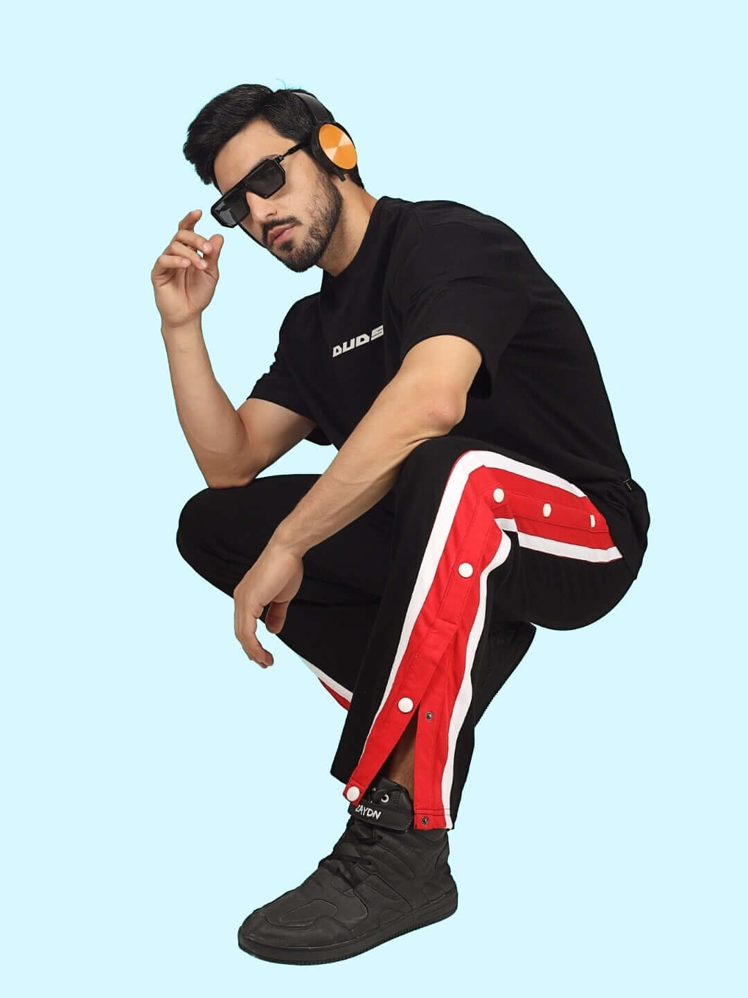 Model wearing DUDS Magician Joggers in Black with red stripe, showcasing style and comfort. Ideal for customizable, made-to-order fashion.